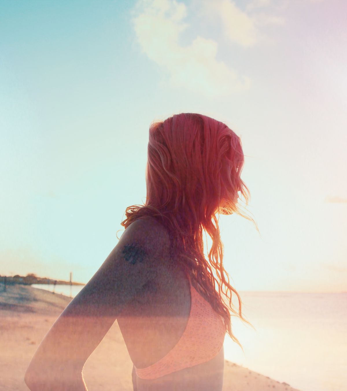 A Woman With Long Hair And A Sunset In The Background